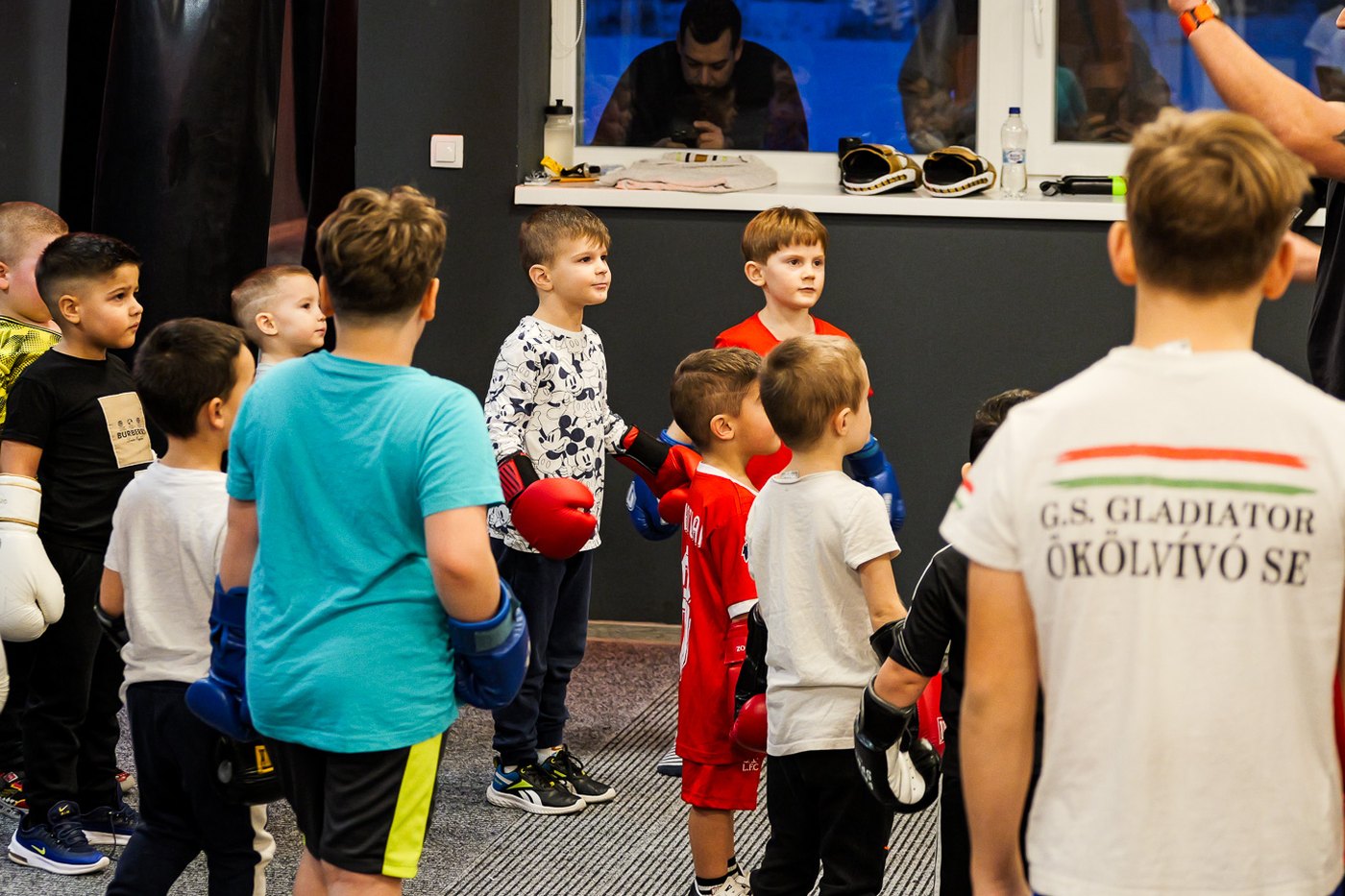Gyerekek kesztyűben az edzés eligazításán a G.S. Gladiátor termében